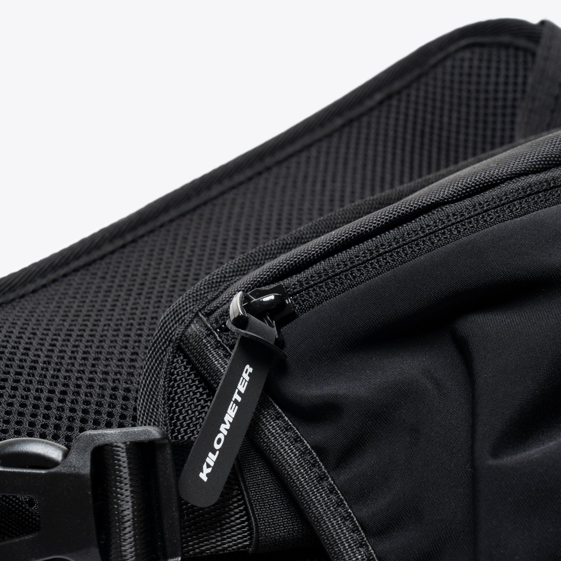 Black running fanny pack zipper detail, KILOMETER label