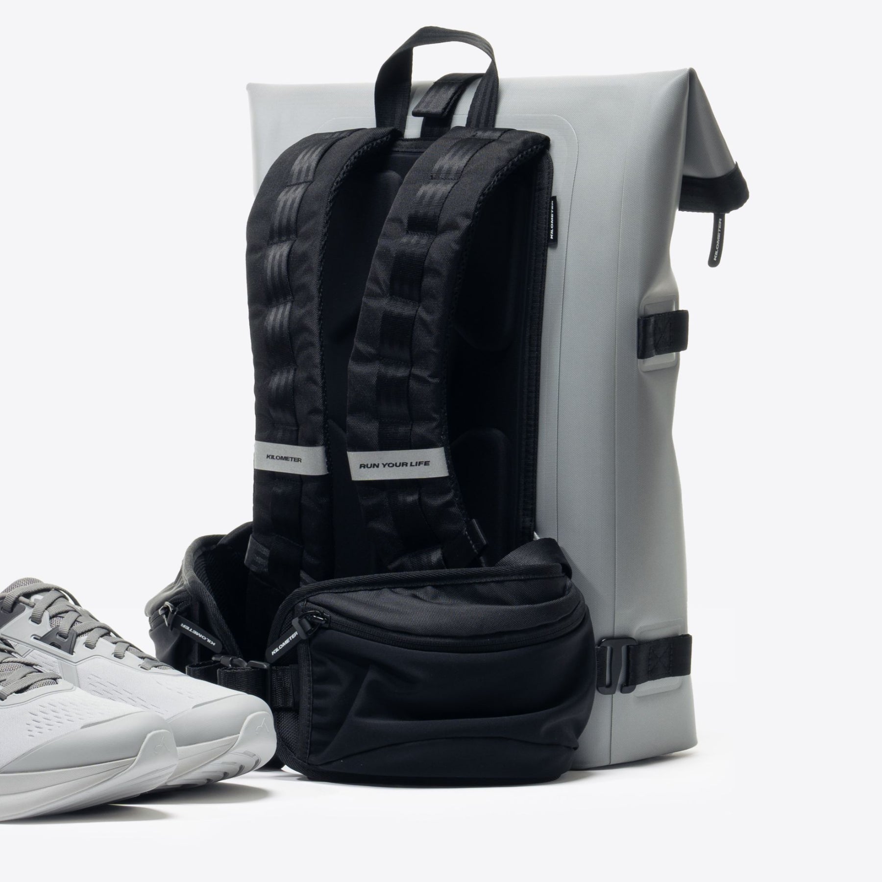 Urban running kit: gray running shoes, black backpack, and fanny pack