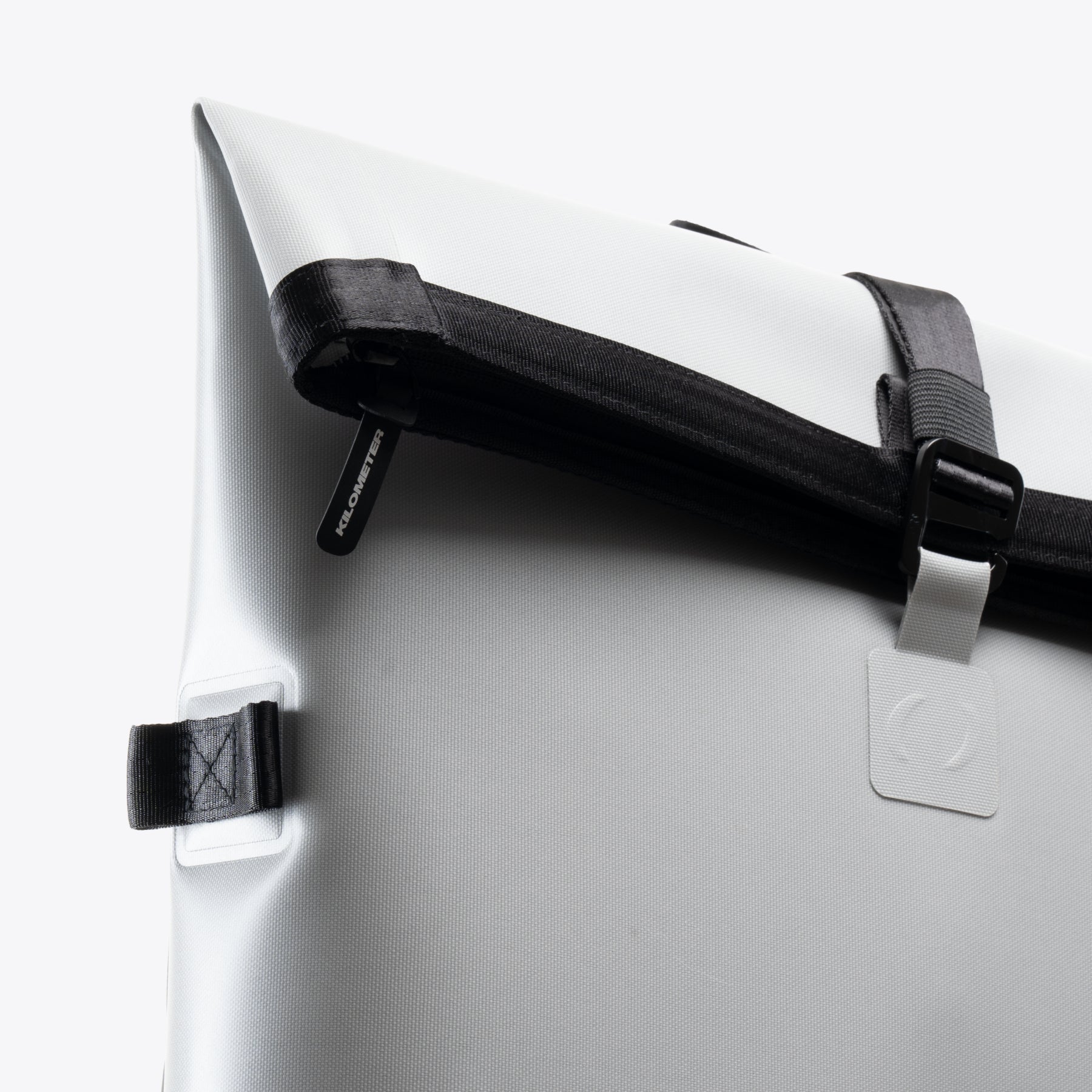 White roll-top backpack detail with black straps, Urban Running Kit