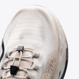 R1 Legacy trail running shoe close-up. Cream and tan colorway, dirty, with ZeroSag branding.
