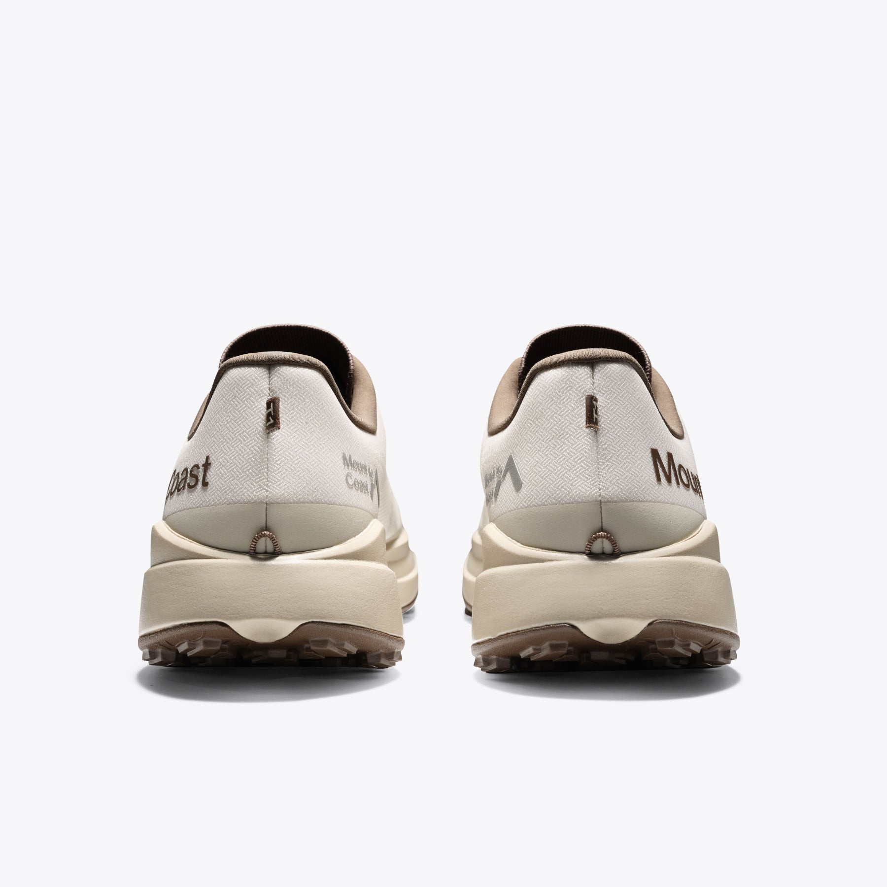 Mount to Coast T1 trail running shoes rear view. Beige and brown colorway. Brand logo and design detail on the heel.
#Color_dune
