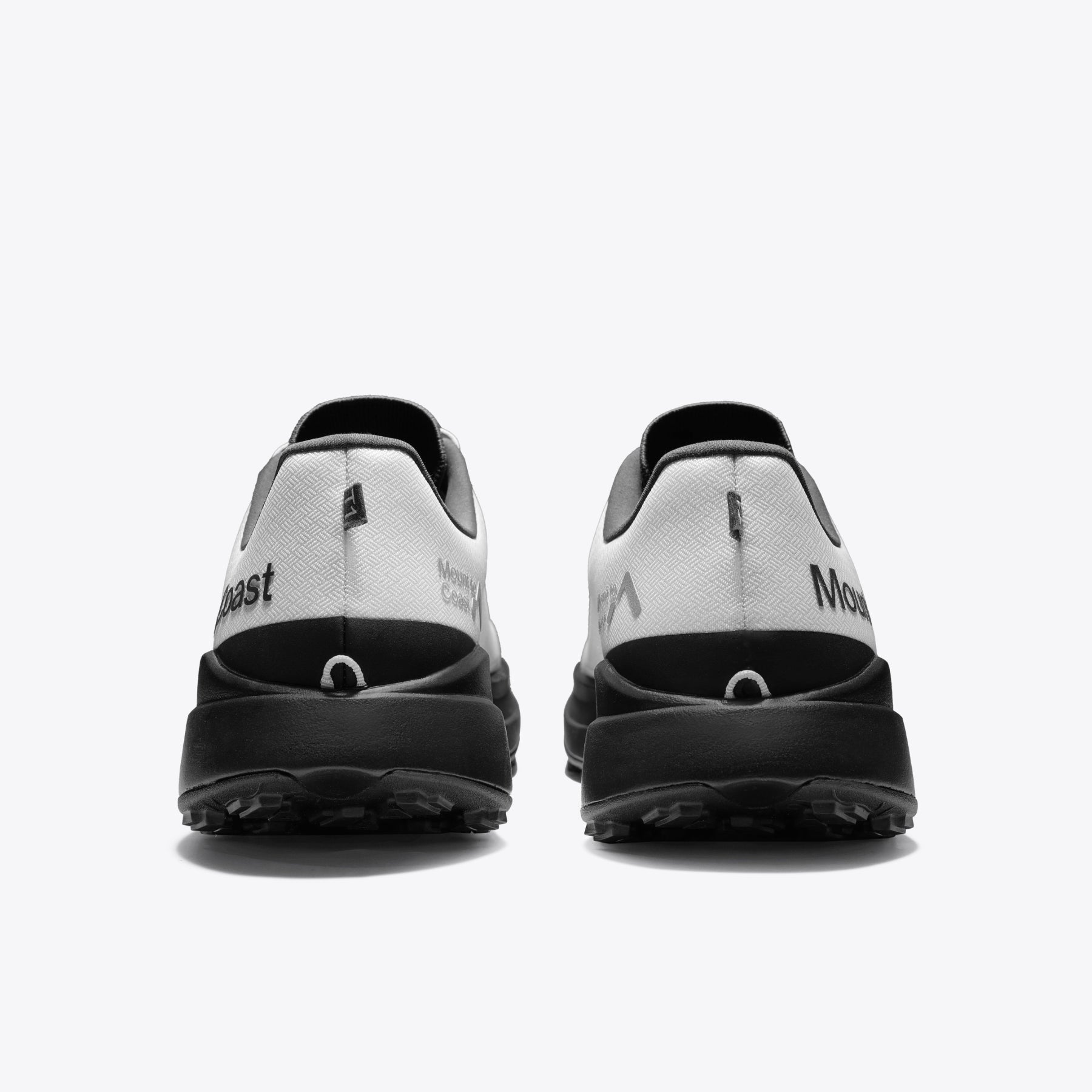 Mount to Coast T1 trail running shoes rear view in white and black colorway. Showcasing the brand logo and design detail.
#Color_tephra