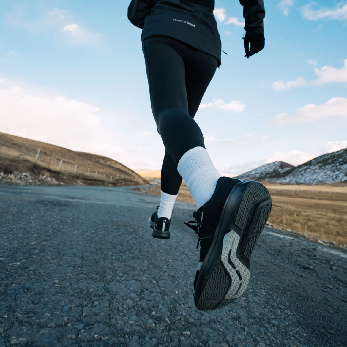 Runner wearing Mount to Coast R1 shoes on road #Color_black