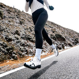 Mount to Coast R1 road running shoe in action, white shoe with black sole, runner on the road #Color_white|black