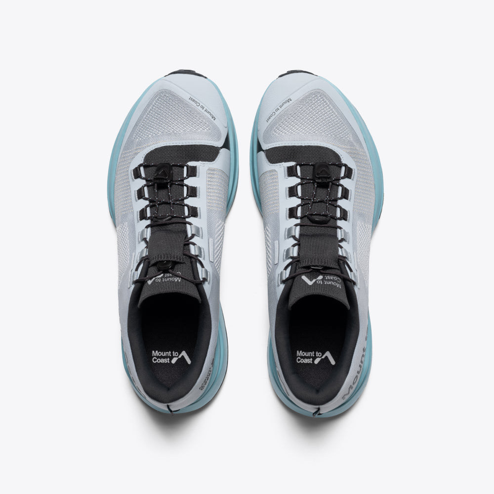 Mount to Coast T1 trail running shoe with light grey upper, teal midsole. Lightweight design for trail running.