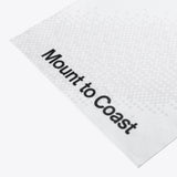 White neck gaiter with Mount to Coast logo on a white patterned background, designed for sun protection and performance.