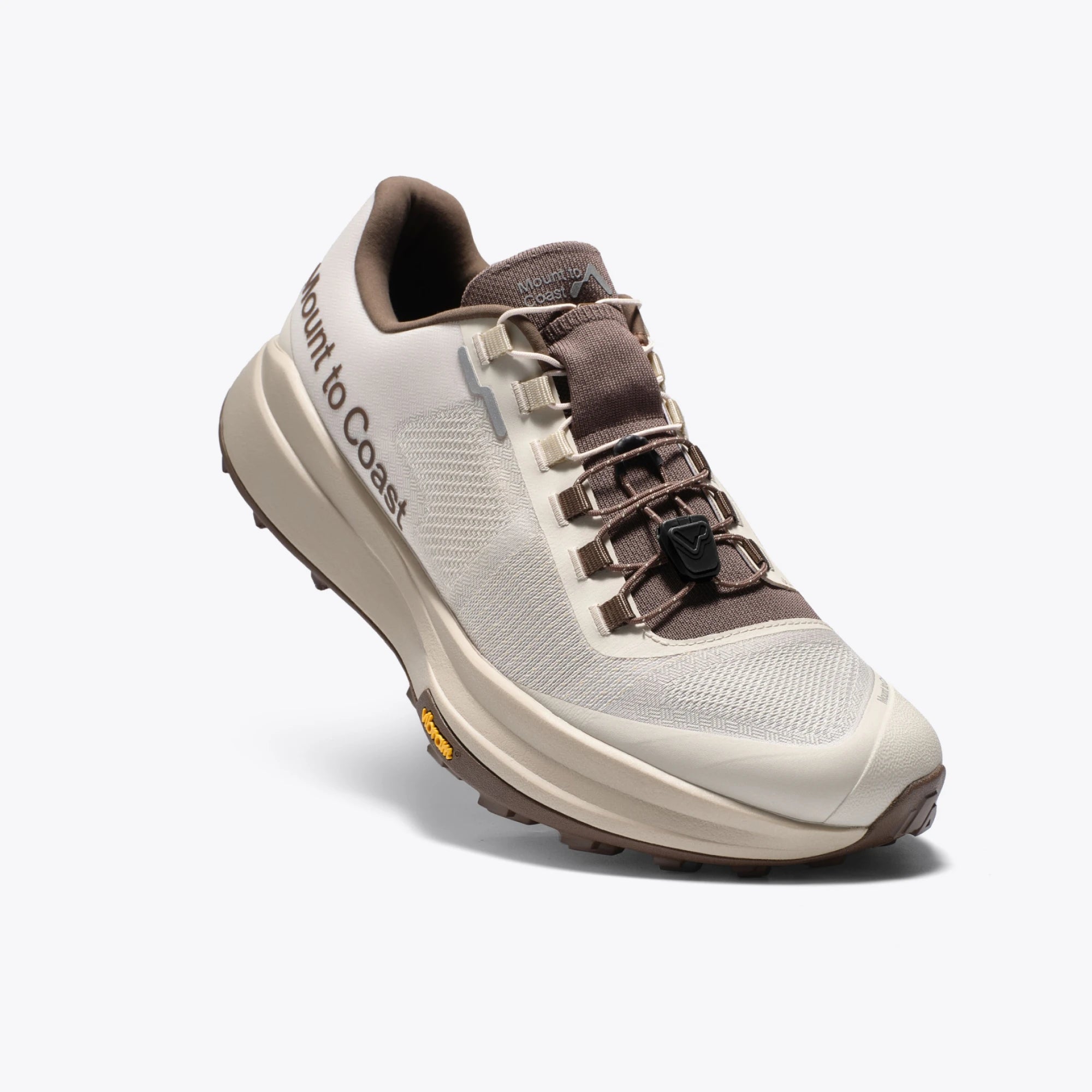 Mount to Coast T1 trail running shoe in beige and brown colorway, featuring Vibram outsole and brand name on the side.
#Color_dune